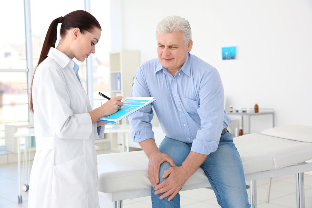 Seorang dokter meresepkan pengobatan untuk pasien untuk arthrosis sendi lutut